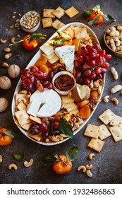 Big cheese board with appetizer assortment. Grape, cheese, nuts, jam and bread.