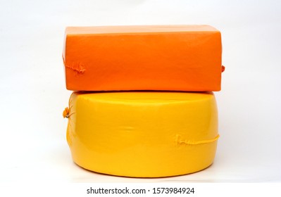 Big Cheese Head, Cheese Wheel  In Yellow Vacuum Package. Cheese Block And Cheese Wheel Isolated On White Background