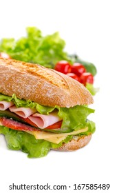 Big Ciabatta Sandwich With Lettuce, Slices Of Fresh Tomatoes, Ham, Salami And Cheese And Ingredients Isolated On White