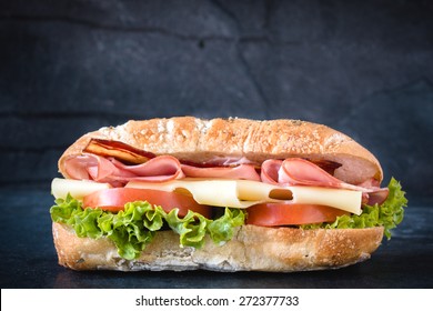 Big Ciabatta Sandwich With Meat And Cheese On Dark Background 