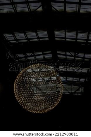 Big circle globe light like earth planet star in space or universe hang on the ceiling with dark background. Textures created from Breathtaking round modern led chandelier, No focus, specifically.