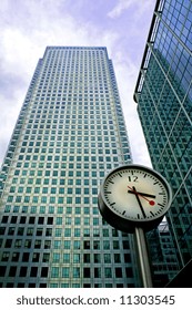 Big clock in front of two business buildings
