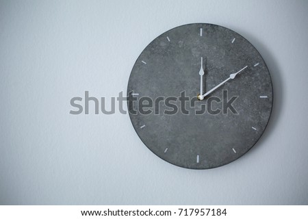 Big clock hanging on grey wall