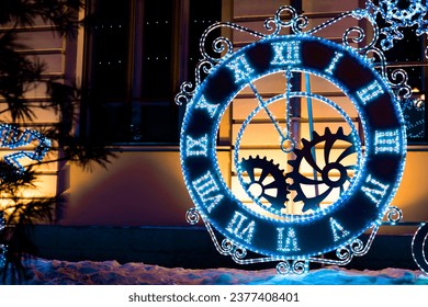 Big clock with Roman numerals on clock face decorated with lights garland outdoors in winter during Christmas holidays with copy space - Powered by Shutterstock