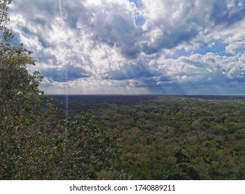 Big clouds with rays of light over the tropical forest. View from the top of the tallest Mayan pyramid in Coba located in the Mexican state of Quintana Roo.
