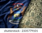 big colorful waving national flag of michigan state on a american dollar money background. finance concept