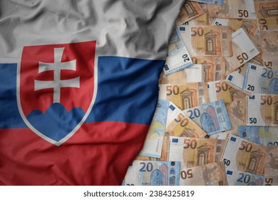 big colorful waving national flag of slovakia on a euro money background. finance concept