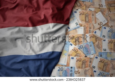 big colorful waving national flag of netherlands on a euro money background. finance concept