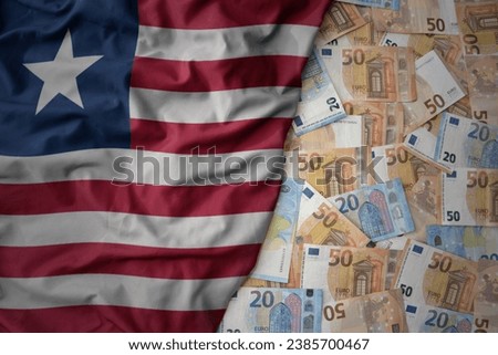 big colorful waving national flag of liberia on a euro money background. finance concept