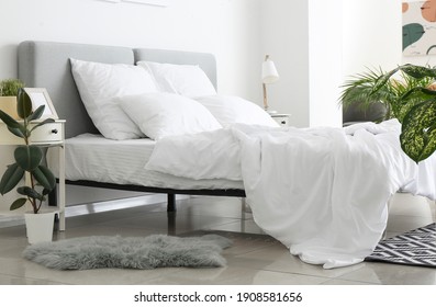 Big comfortable bed with clean linen in room - Shutterstock ID 1908581656