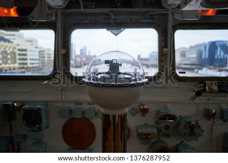 Big compass with other instruments for navigation on the captain bridge of old historical british war ship who served belong Royal Navy during World war two in the north atlantic to protect convoys.