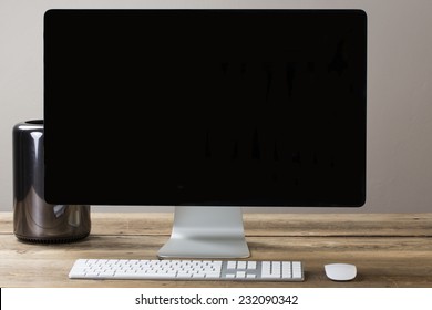 big computer screen on a wood table with stationary items - Powered by Shutterstock