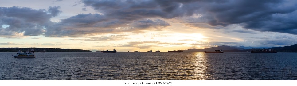 Big Container Ship parked in Burrard Inlet on the West Coast of Pacific Ocean. Colorful cloudy sunset sky. Vancouver, British Columbia, Canada. Panorama Nature Background