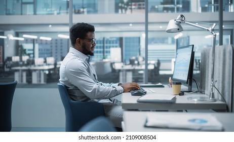 In Big Corporate Office: African American Business Manager Using Computer, Businesspeople and Experts Working Around Him, Analysing Statistics, Commerce Data, Marketing Plans.