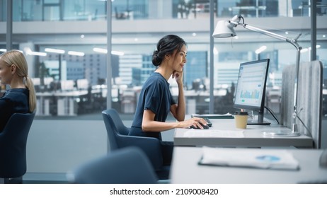 In Big Corporate Office: Beautiful Asian Business Manager Using Computer, Businesspeople and Experts Working Around Her, Analysing Statistics, Commerce Data, Marketing Plans.