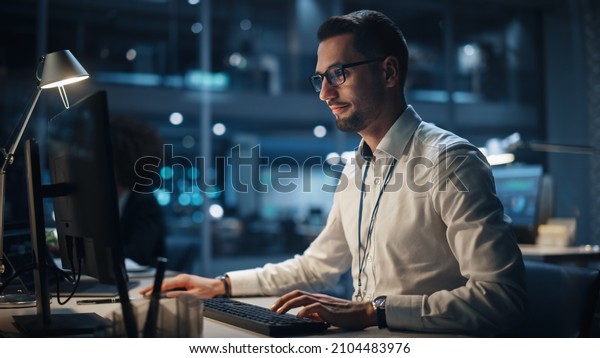 In Big Corporate Office at Night: Portrait of\
Confident Manager in White Shirt Using Computer, Businesspeople and\
Experts Working Around Him, Analysing Statistics, Commerce Data,\
Marketing Plans.
