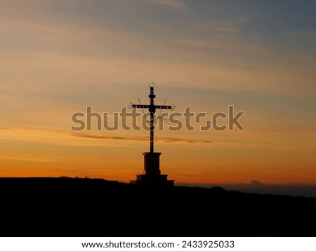 Big cross on top of a mountain in the evening sun 