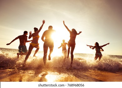 Big crowd of people having fun at sunset beach - Shutterstock ID 768968056