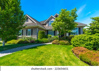 Big custom made luxury house with nicely landscaped front yard in the suburb of Vancouver, Canada.
