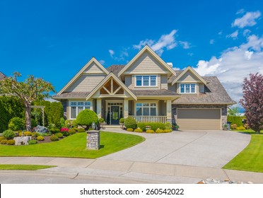 Big custom made luxury house with nicely landscaped front yard and driveway to garage in the suburb of Vancouver, Canada.