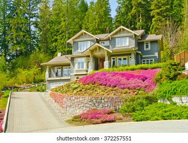 Big Custom Made Luxury House On The Rocky Slope With Nicely Landscaped Front Yard And Driveway To Garage In The Suburbs Of Vancouver, Canada.