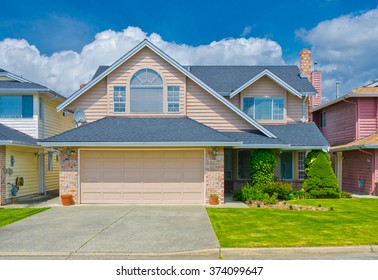 Big Custom Made Luxury House With Nicely Trimmed And Landscaped Front Yard And Driveway To Garage In The Suburbs Of Vancouver, Canada.