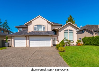 Big Custom Made Luxury House With Nicely Trimmed And Landscaped Front Yard And Driveway To Garage In The Suburbs Of Vancouver, Canada.