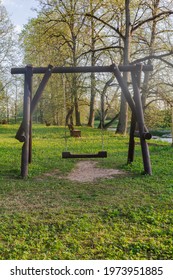 Big Dark Wooden Swing In Forest Outdoor Park With No People Looks Very Peaceful In Countryside Vertical View