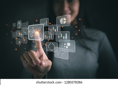 Big data analytics and business intelligence concept with chart and graph icons on a digital screen interface and a businesswoman in background