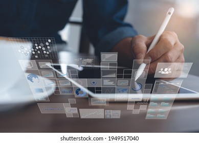 Big data analytics and business intelligence (BI) concept with chart and graph icons on modern dashboard digital screen interface and businessman  working on digital tablet in office as background