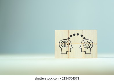 Big data and artificial intelligence concept. Machine learning and cyber mind domination concept. Human brain mind head with AI robot head symbols on wooden cubes on grey background. Humanoid banner.