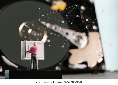 Big data concept-miniature engineer working with drafting table with open hard disk background