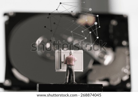Big data concept-miniature engineer working with drafting table with open hard disk and  social network diagram
