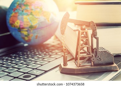 Big data and data mining concept : Oil or petroleum pump jack on a laptop computer keyboard, depicts the collective data / info or extraction technic that are performed on large sets / volume of data. - Shutterstock ID 1074373658