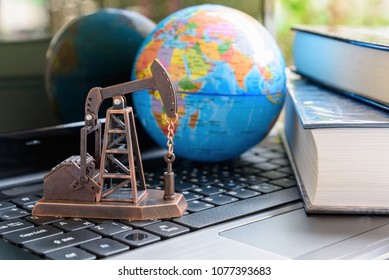 Big data and data mining concept : Oil or petroleum pump jack on a laptop computer keyboard, depicts the collective data / info or extraction technic that are performed on large sets / volume of data.
