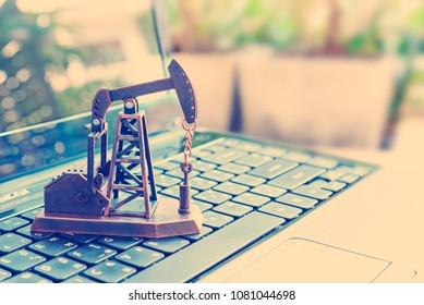 Big data and data mining concept : Oil or petroleum pump jack on a laptop computer keyboard, depicts the collective data / info or extraction technic that are performed on large sets / volume of data.