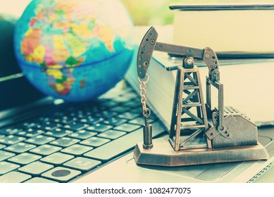 Big data and data mining concept : Oil or petroleum pump jack on two thick books, depicts the collective data or extraction technic that are performed on large sets / volume of data, uncovering info.