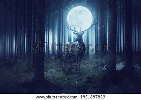 Big deer with moon stands in a dark mystical forest
