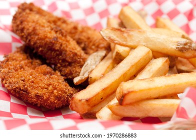 A Big Diner Style Plate Of Breaded Chicken Tenders And Hand Cut French Fries