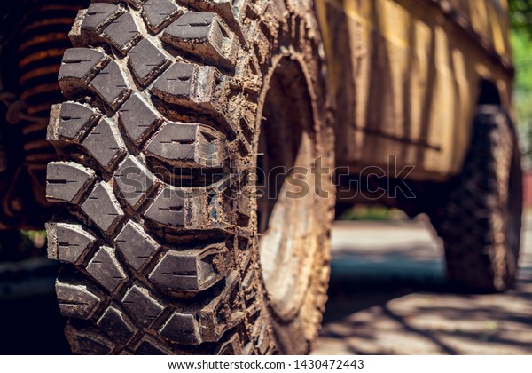 Big and dirty tires of a truck on a bright\
sunny day – Used rubber wheels with a detailed texture and rough\
surface – Off road car for extreme\
sports