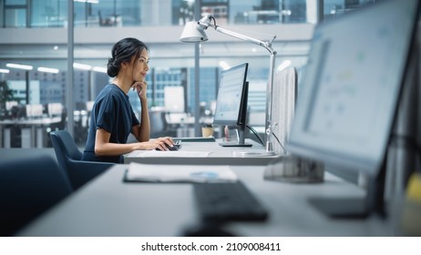 In Big Diverse Corporate Office: Portrait Beautiful Asian Manager Using Desktop Computer  Businesswoman Managing Company Operations  Analysing Statistics  Commerce Data  Marketing Plans 