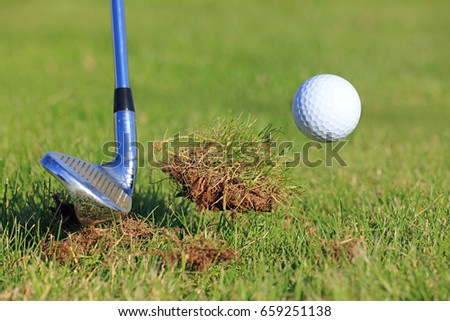Big Divot While Chipping Golf Ball Out Of The Rough Grass.