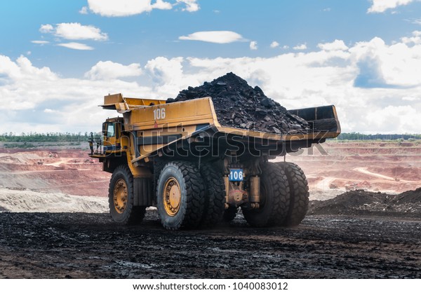 Big dump truck or Mining truck is mining machinery,\
or mining equipment to transport coal from open-pit or open-cast\
mine as the Coal Production. This picture show dump truck on\
open-pit coal mine.