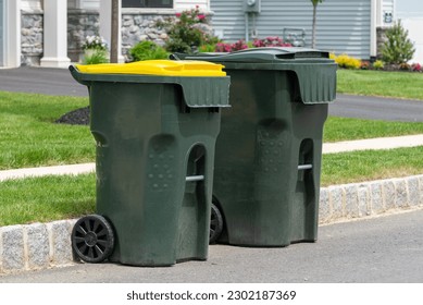 big empty green plastic trash garbage bin in front of the modern house junk road public