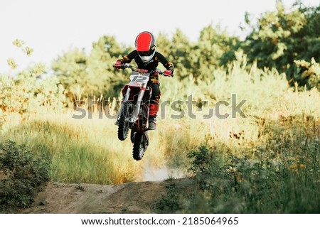 Big energy. Live shot of junior sportsman, motorcyclist training on motorbike at hot summer day, outdoors. Motocross sport, competition, male hobby, energy and ad