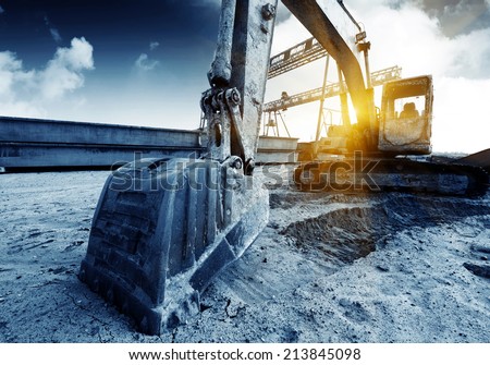 Big excavator on new construction site, in the background the blue sky and sun