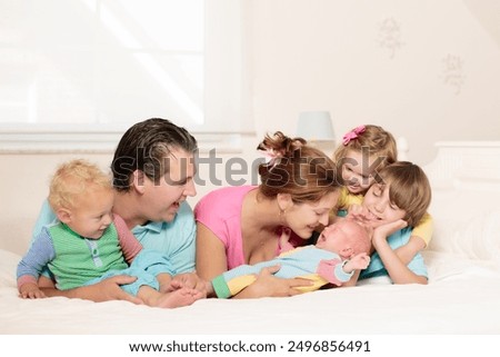 Children feeding doll with cookie sitting over the bed