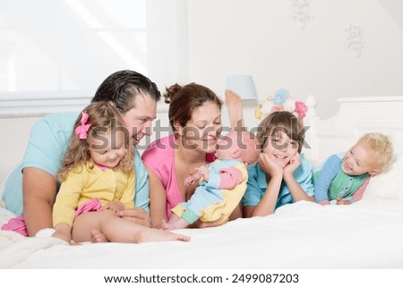 Similar – Children feeding doll with cookie sitting over the bed