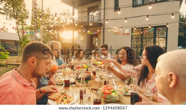 Big Family Garden\
Party Celebration, Gathered Together at the Table Relatives and\
Friends, Young and Elderly are Eating, Drinking, Passing Dishes,\
Joking and Having Fun.