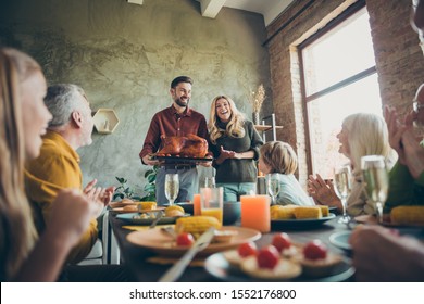 Big Family Happy Gathering On Thanksgiving Day Celebration Couple Hold Plate With Roast Meat To Small Little Children Mature Relative Sit Table Enjoy Meal Candles Decoration Corns In House